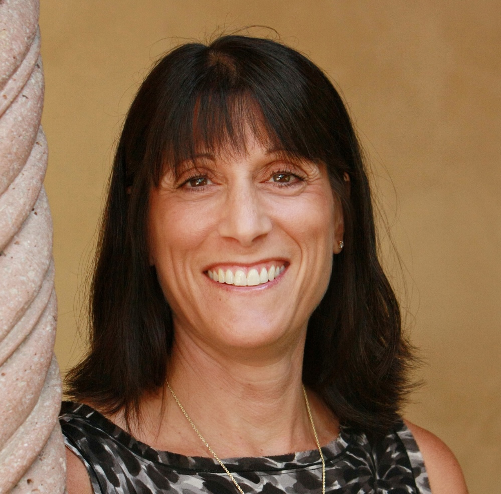 Portrait of Amy Marcus-Newhall, president of Scripps College, a white woman with shoulder-length dark brown hair.