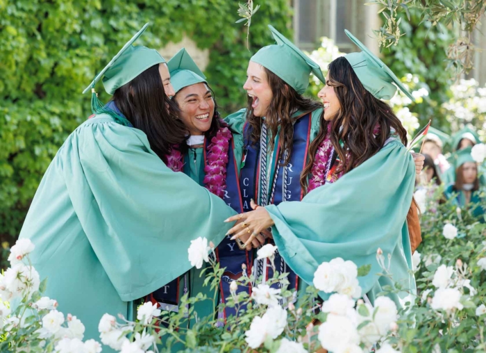 Four graduates congratulate each other