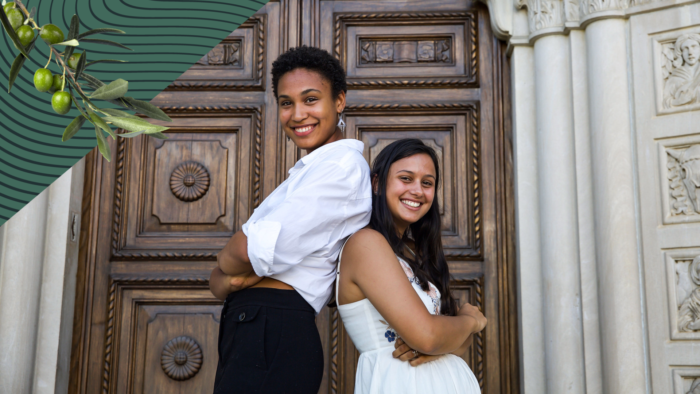 Two students smiling standing back to back