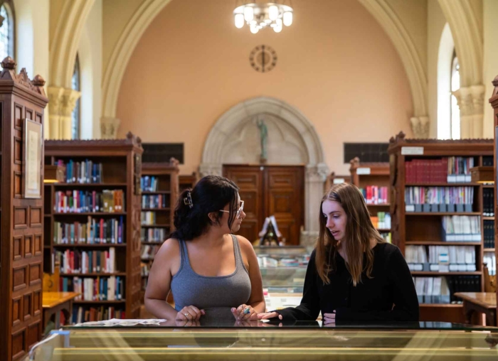 Two student viewing the content in the display cases inside Denison Library