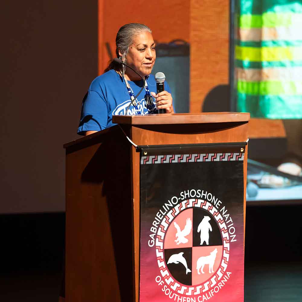 Person from Gabrielino-Shoshone Nation on stage at podium during a Scripps Presents event.