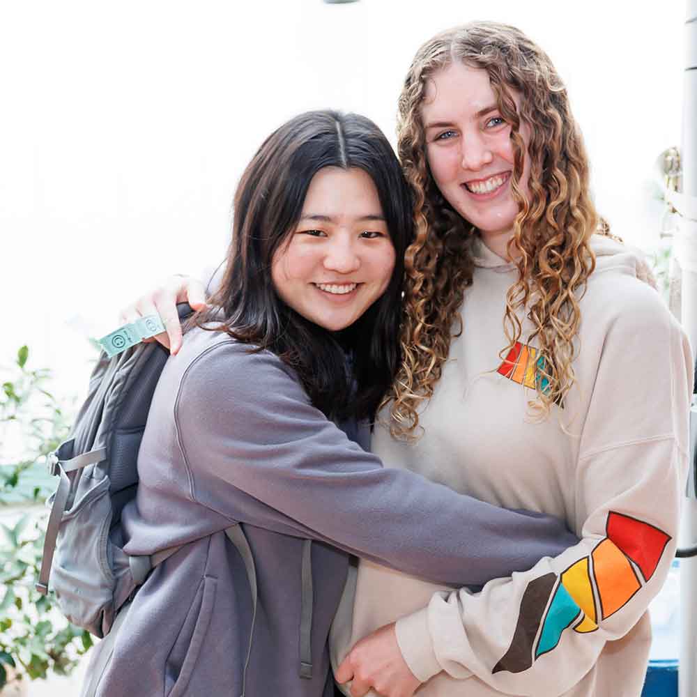 Two students smiling in an embrace