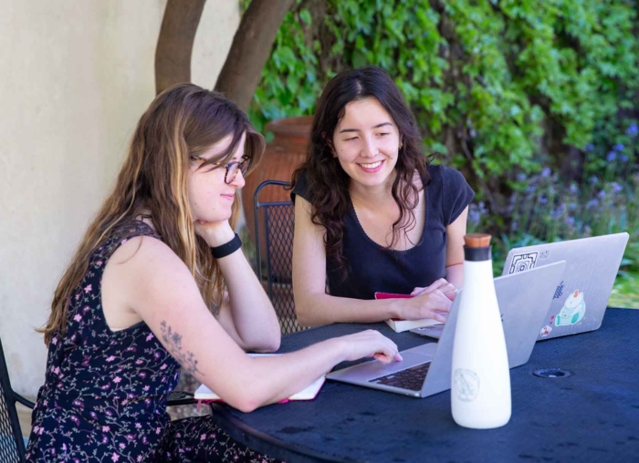 Two students outside on a laptop