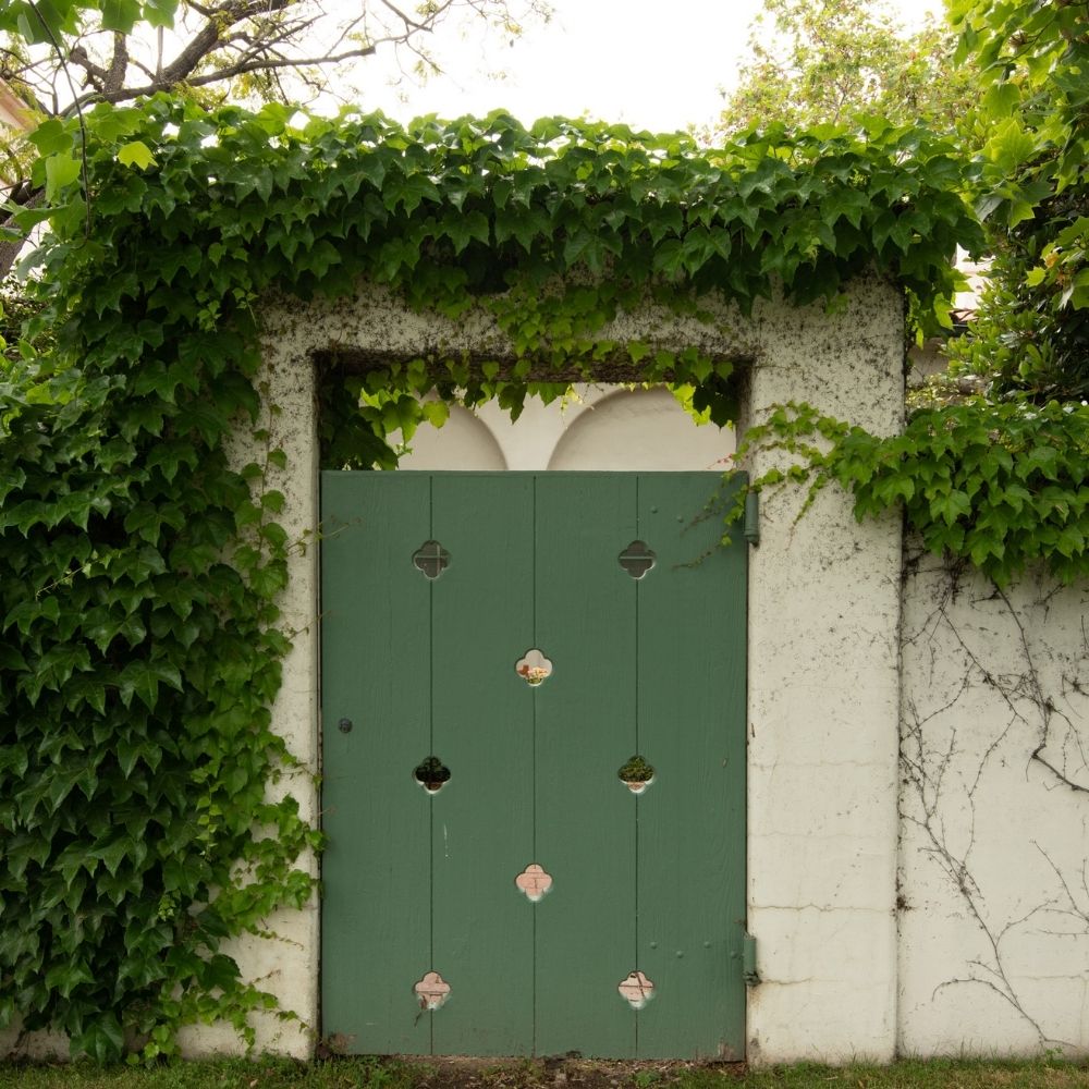 A green wooden door leads to a courtyard on the Scripps College campus in Southern California