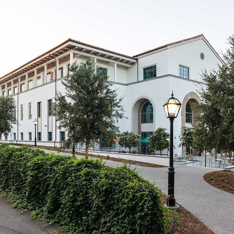 Exterior shot of The Nucleus science center, a three-story white building surrounded by trees